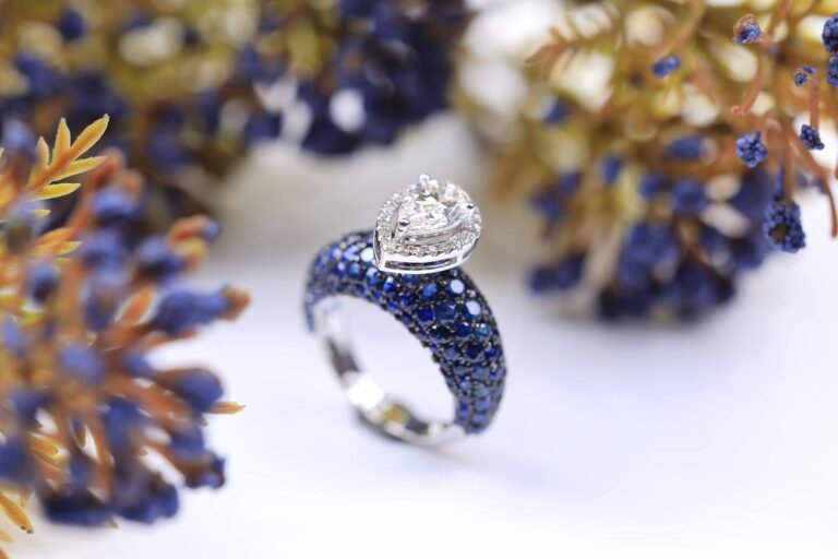 A close-up of a luxurious diamond and sapphire ring against a floral backdrop, highlighting elegance.