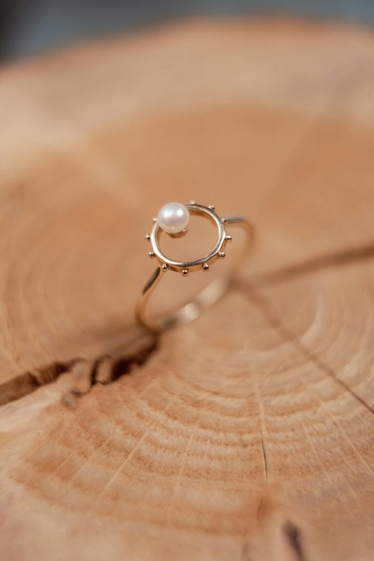 Close-up of a delicate pearl ring elegantly placed on a wooden surface, showcasing its elegance and craftsmanship.